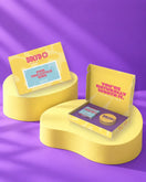 Giftbox 'A babyshower for the little one' op gele sokkels in paarse studio