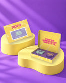 Giftbox 'Welcome to your fresh start' op gele sokkels in paarse studio