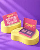Giftbox Pink Ribbon op gele sokkels in paarse studio