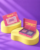 Giftbox 'Say it with a flower shower' op gele sokkels in paarse studio